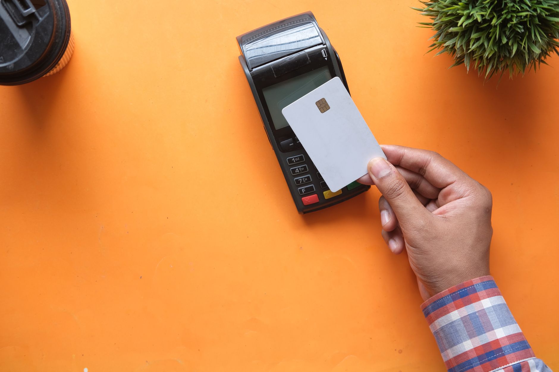 Un terminal de pago sin contacto sobre el mostrador de una tienda, que representa el negocio de pagos para comercios de Adyen.