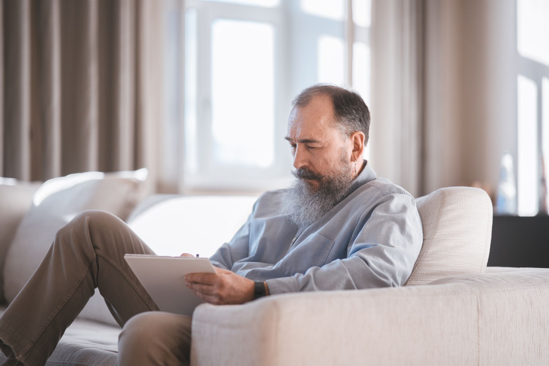A person checks an investment account on a tablet, representing the UK retail investing platforms competing for customers.