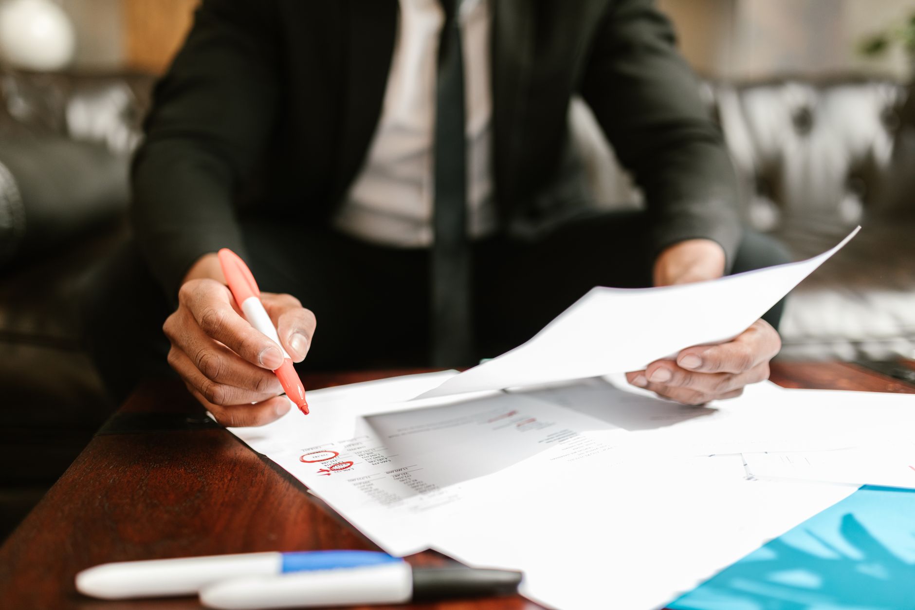 A calculator beside account paperwork on a broker's desk, illustrating client acquisition costs.