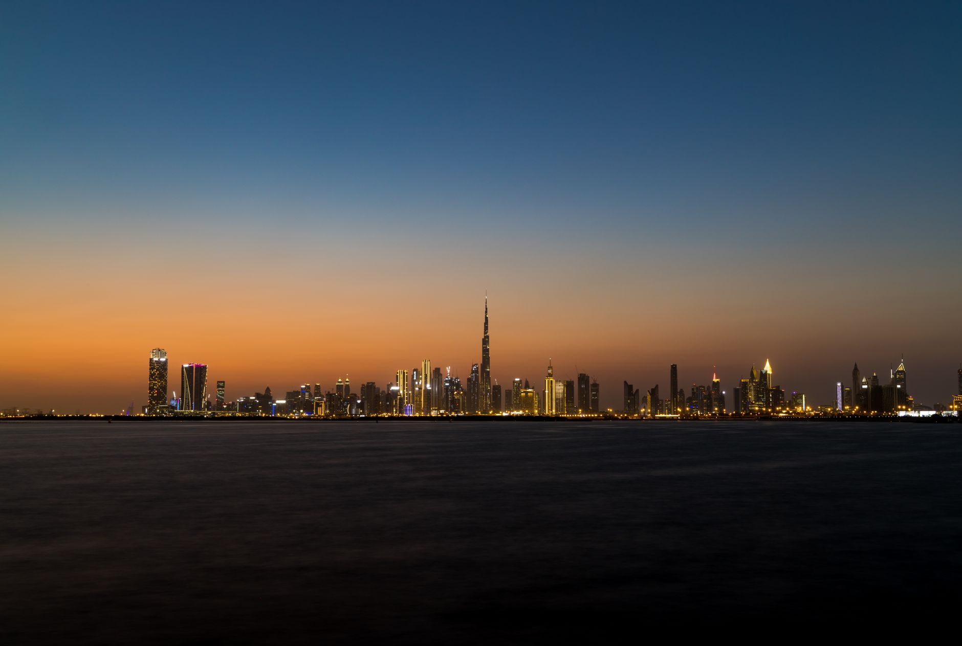 Um smartphone exibe um gráfico de trading diante do horizonte de Dubai, ilustrando a licença da Bybit para trading spot na cidade.