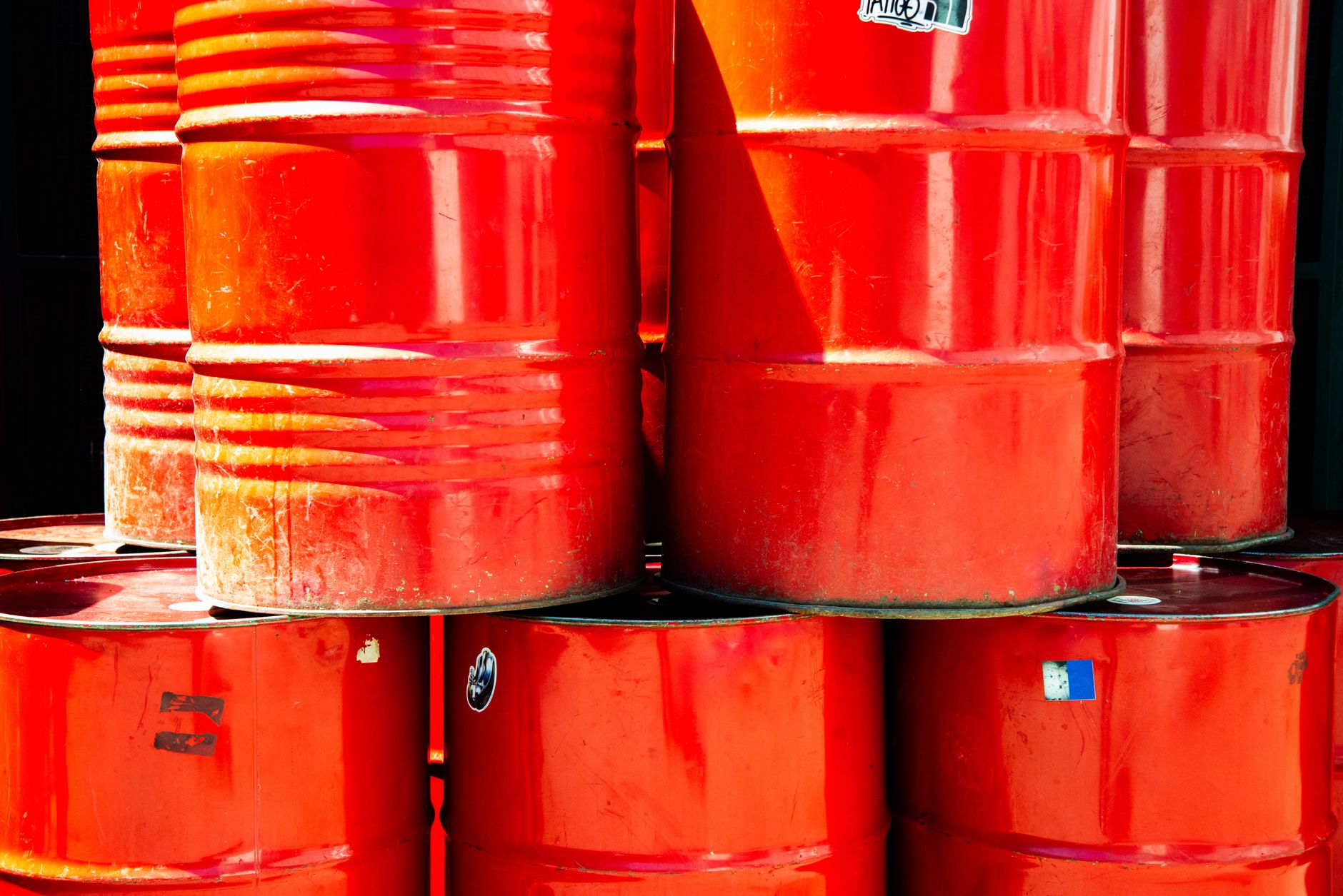 Barriles de petróleo junto a un terminal de trading, en referencia al contrato perpetuo de WTI propuesto por Kalshi