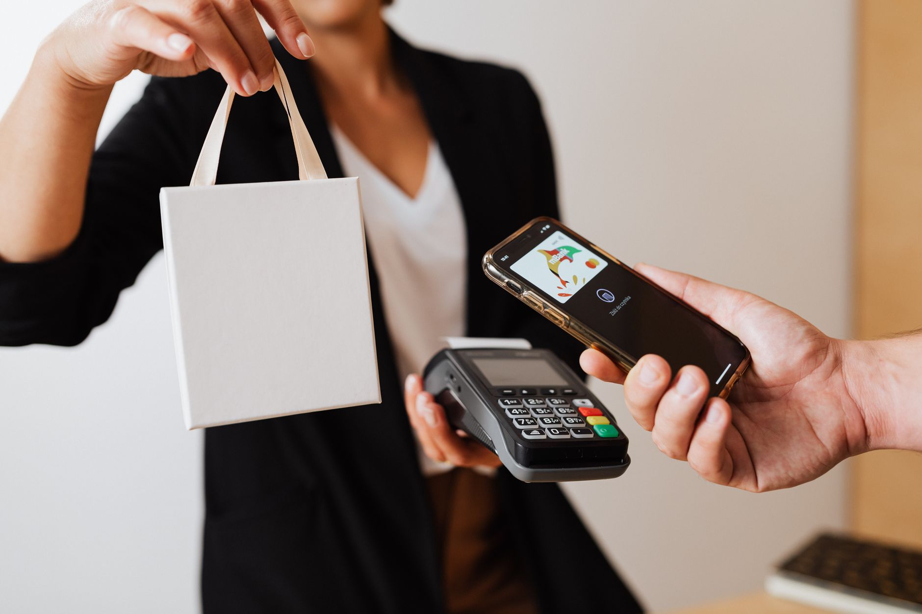 Una persona usa el teléfono al pagar, en una imagen que ilustra la billetera y el producto de pagos para comercios de Accrue.