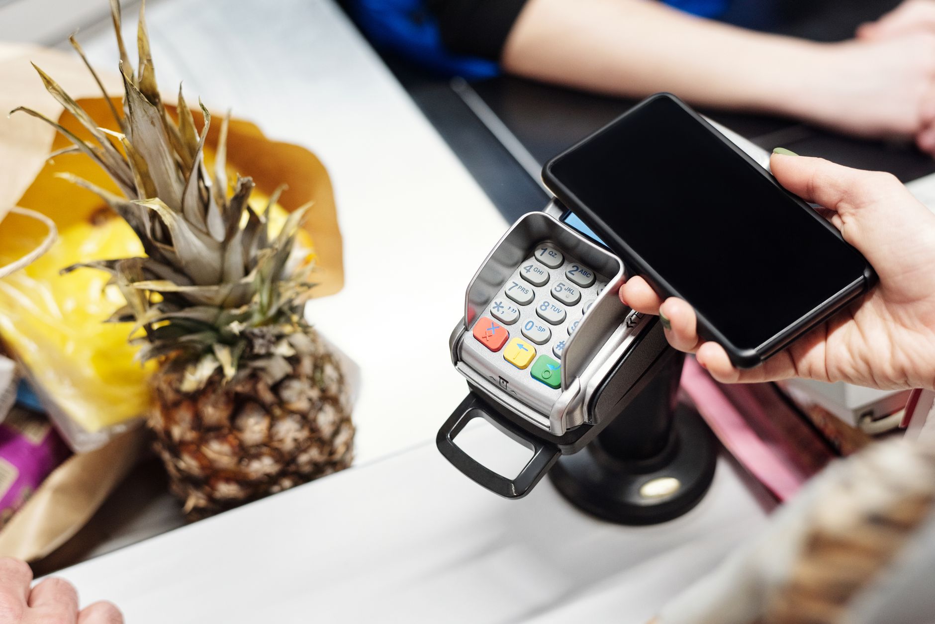 Un comprador usa el teléfono al pagar, como ilustración de una cartera digital integrada en un comercio.