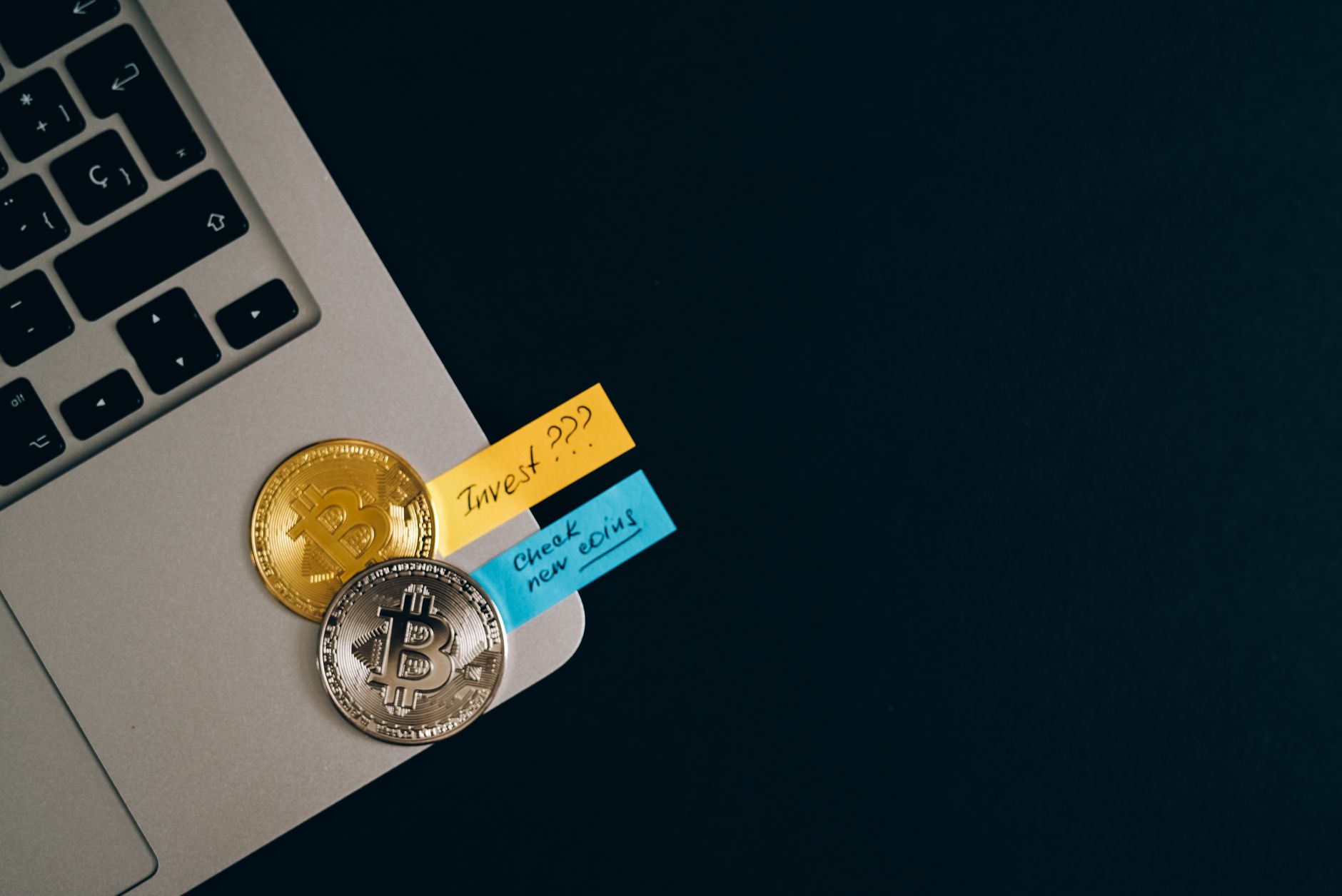 Cryptocurrency tokens beside a laptop, illustrating the crypto-linked transfer investigation in India.
