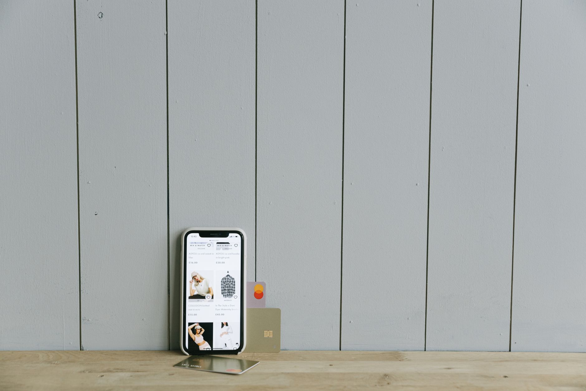 A person holds a payment card beside a smartphone, illustrating the app and card payment disruption reported by Revolut.
