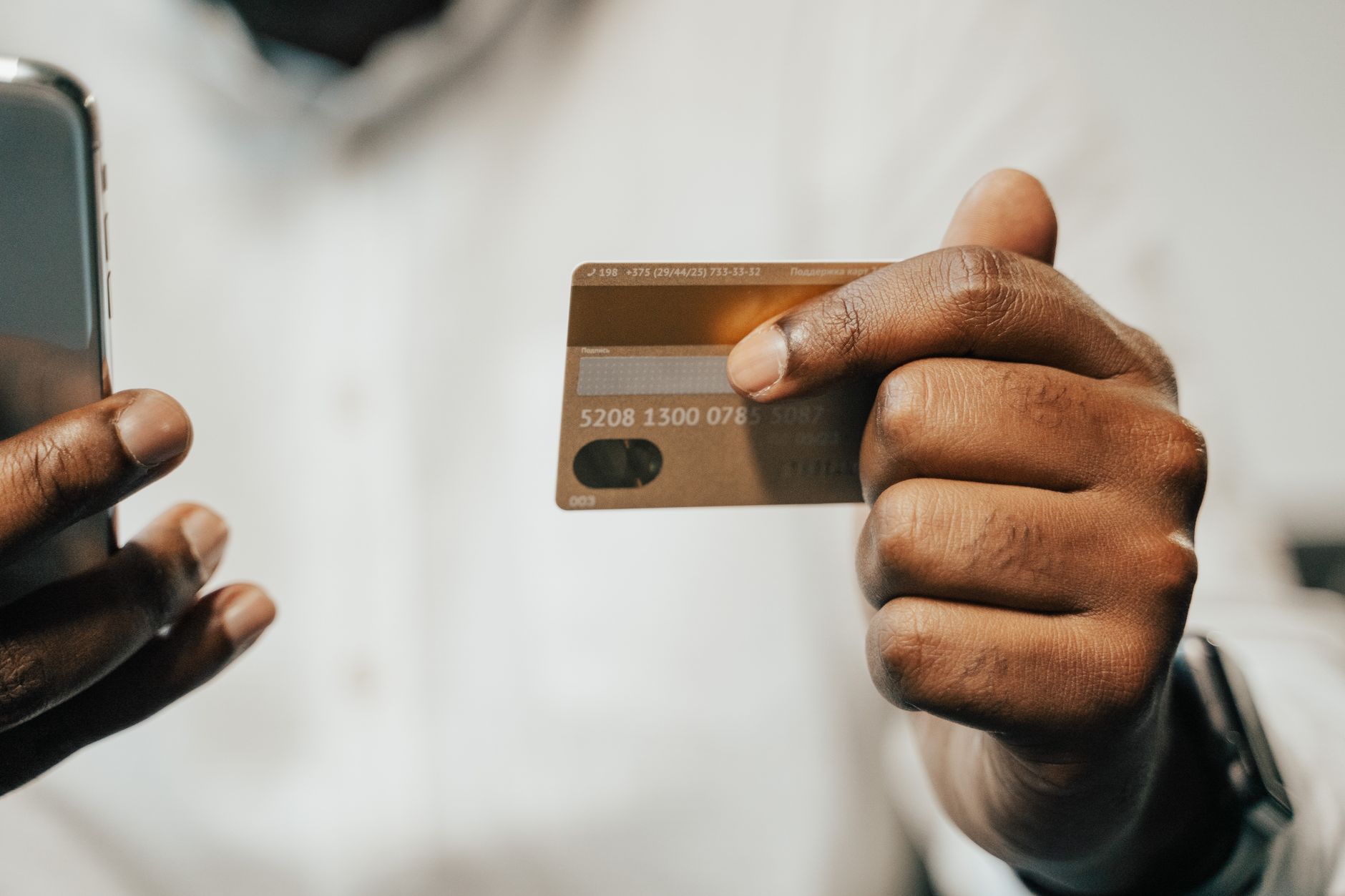 A smartphone beside a bank card, illustrating customer reports of Revolut app and card-payment problems.