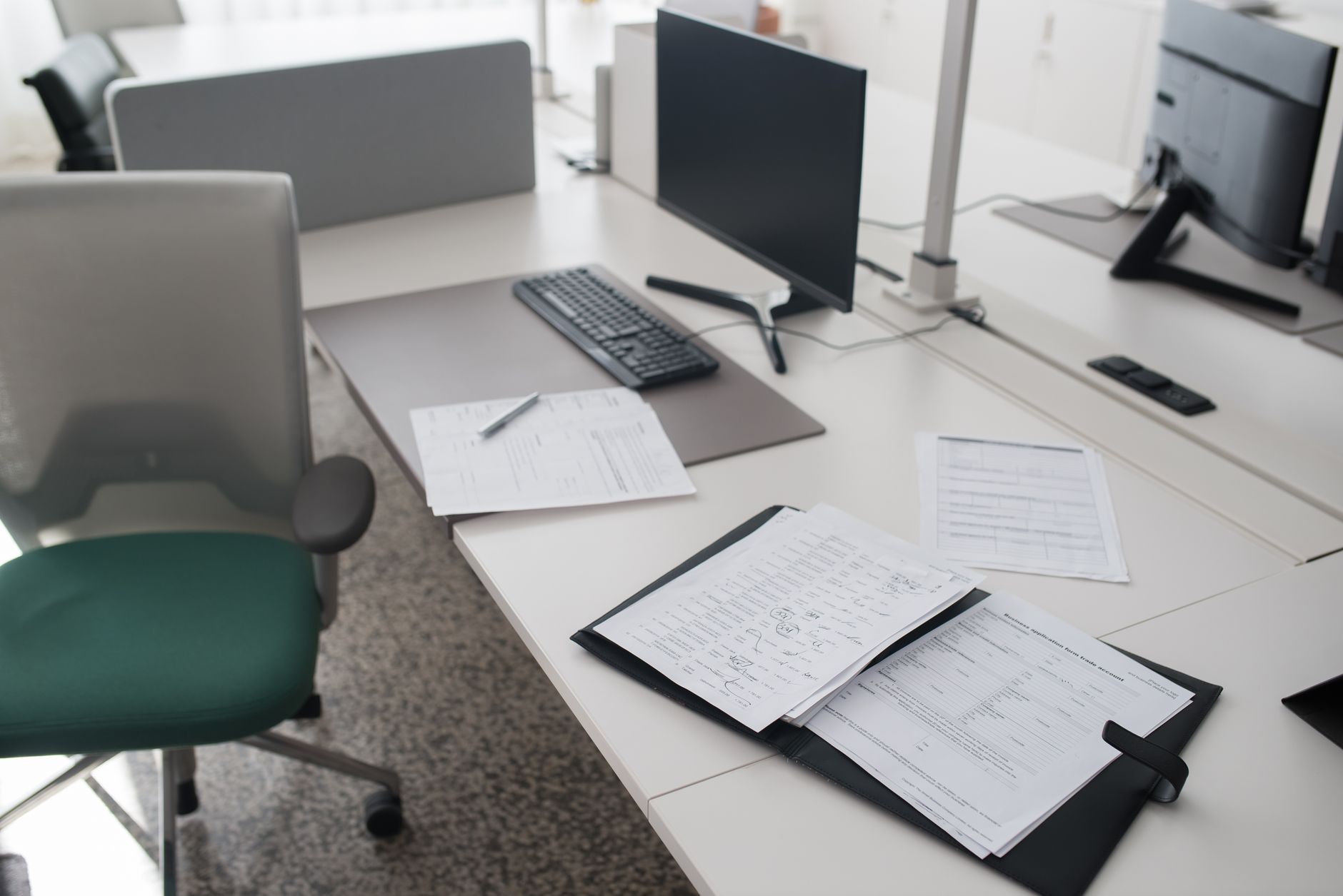 Company records beside a laptop displaying a business filing page, illustrating checks on UK corporate customers.