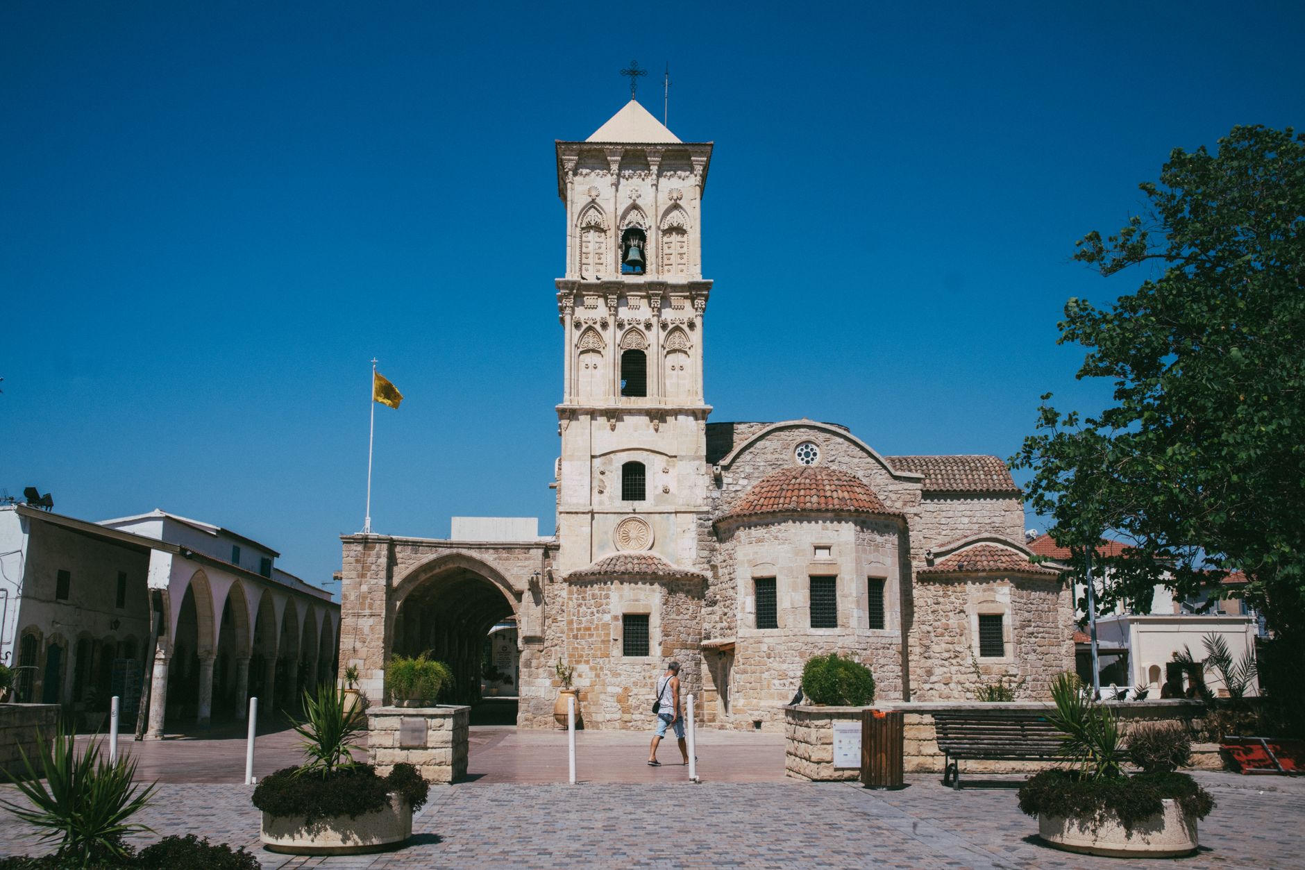 A Cyprus flag outside an office building, illustrating TIOmarkets CY's Cyprus authorisation withdrawal.