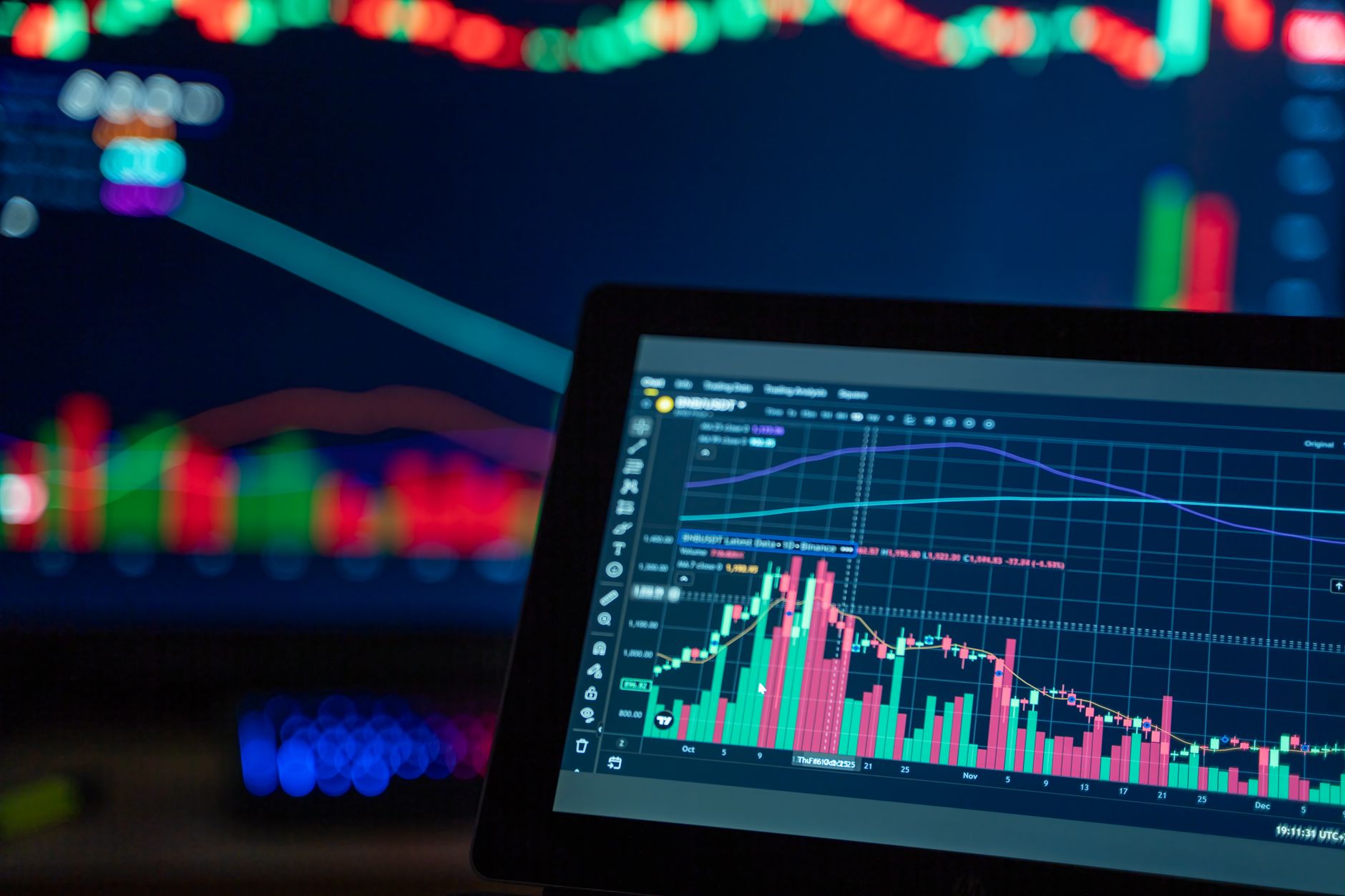 A laptop displaying trading charts, illustrating the TradingView Marketplace change for paid scripts
